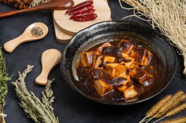 Geleneksel Çin yemeği, baharatlı Mapo Tofu biberli ve acı biberli siyah arka planda..
