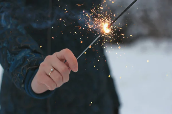 魔法の燃焼スパークラー ツリーの下にクリスマスの輝き 男の手には輝く輝きがある — ストック写真