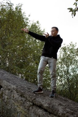 Uzun boylu genç bir adam ateş ediyormuş gibi yapıyor..