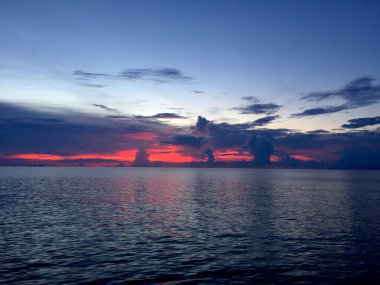 Güzel pembe tonlarıyla okyanus kenarında güzel bir gün batımı.