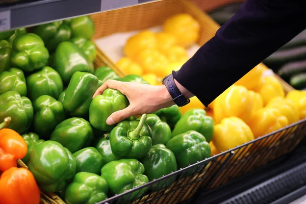 Young man buying vegetables at the market