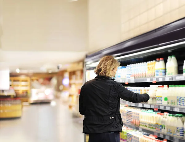 Supermarket shopping, face mask and gloves,Young man shopping in supermarket, reading product information