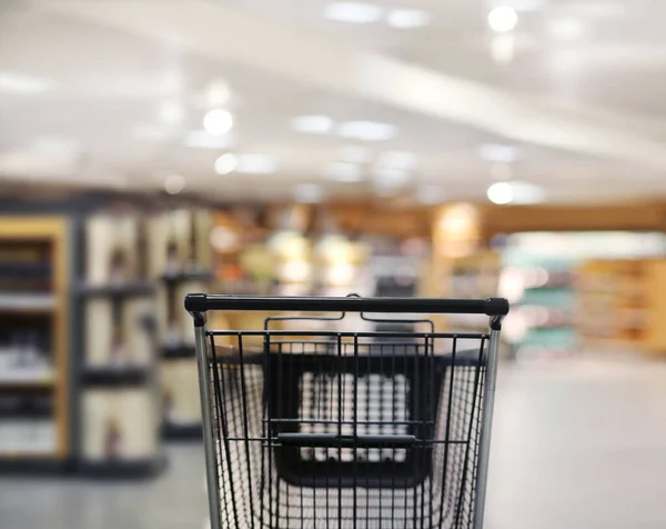 empty grocery cart in an empty supermarket, pandemic, Abstract blurred supermarket aisle .