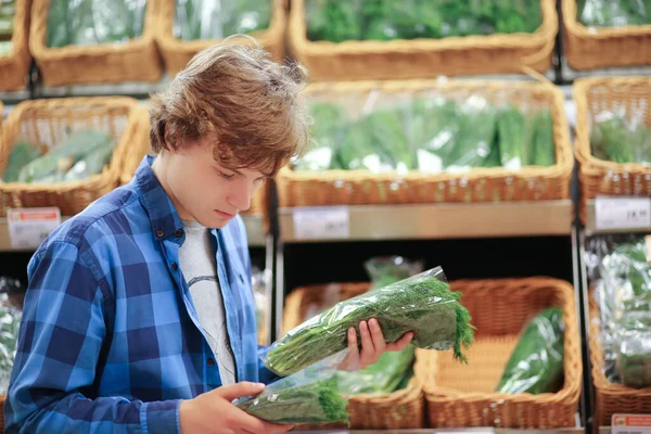 Young man buying vegetables at the market   .Young man in the supermarket .