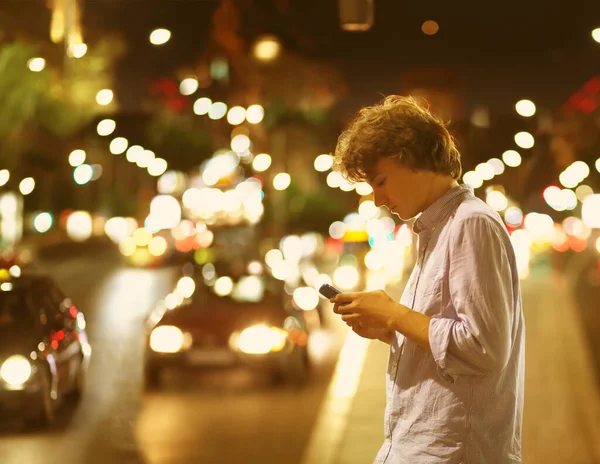 Lifestyle portrait of a teenage boy using a smart phone outdoors