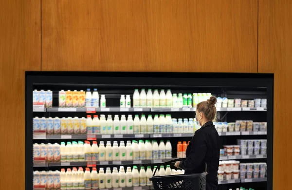 supermarket shopping, face mask and gloves,Woman choosing a dairy products at supermarket