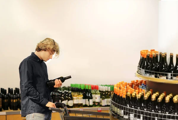man choosing a wine, champagne at supermarket