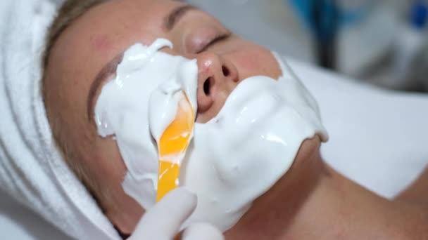 Cosmetólogo Aplica Máscara Alginato Con Espátula Cara Mujer Piel Facial — Vídeo de stock