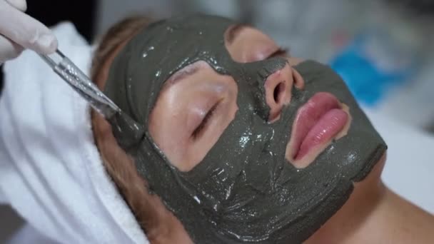 Cosmetólogo Aplicar Mascarilla Arcilla Con Cepillo Cara Joven Mujer Bonita — Vídeos de Stock