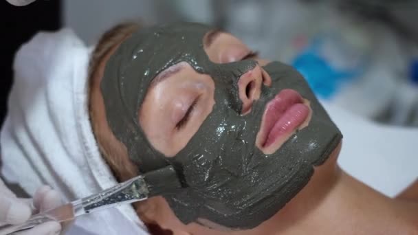 Αισθητικός Εφαρμογή Πήλινη Μάσκα Πινέλο Νεαρή Όμορφη Γυναίκα Πρόσωπο Κλινική — Αρχείο Βίντεο