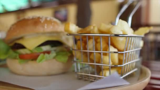 Bord Met Ronddraaiende Cheeseburger Frietjes — Stockvideo