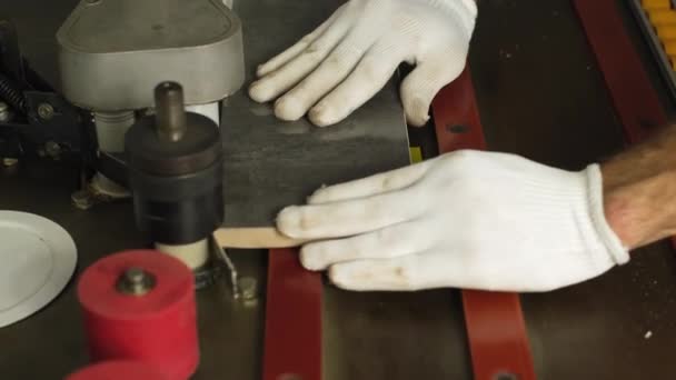木製のチップボード家具を作るプロセス まな板 端を合わせなさい 板に穴を開ける 手袋の男は 工場で家具を作ります 近いショット 作業工程 — ストック動画