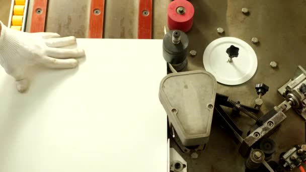 Le processus de fabrication de meubles en panneaux de particules de bois. Planches à découper. Alignez les bords. Faire des trous dans les planches. Un homme en gants fabrique des meubles à l'usine, plans rapprochés. Le processus de travail.          