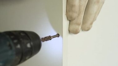 Tahta yonga mobilya yapma süreci. Kesme tahtaları. Kenarları hizala. Tahtada delikler açıyorum. Eldivenli bir adam fabrikada mobilya yapıyor, yakın çekim. Çalışma süreci.          