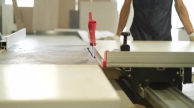 Tahta yonga mobilya yapma süreci. Kesme tahtaları. Kenarları hizala. Tahtada delikler açıyorum. Eldivenli bir adam fabrikada mobilya yapıyor, yakın çekim. Çalışma süreci.          