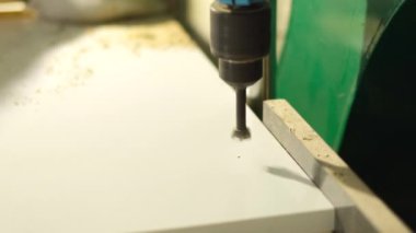 Tahta yonga mobilya yapma süreci. Kesme tahtaları. Kenarları hizala. Tahtada delikler açıyorum. Eldivenli bir adam fabrikada mobilya yapıyor, yakın çekim. Çalışma süreci.          