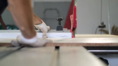 Tahta yonga mobilya yapma süreci. Kesme tahtaları. Kenarları hizala. Tahtada delikler açıyorum. Eldivenli bir adam fabrikada mobilya yapıyor, yakın çekim. Çalışma süreci.          