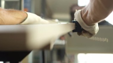 Tahta yonga mobilya yapma süreci. Kesme tahtaları. Kenarları hizala. Tahtada delikler açıyorum. Eldivenli bir adam fabrikada mobilya yapıyor, yakın çekim. Çalışma süreci.          