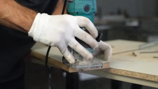 木製のチップボード家具を作るプロセス まな板 端を合わせなさい 板に穴を開ける 手袋の男は 工場で家具を作ります 近いショット 作業工程 — ストック動画