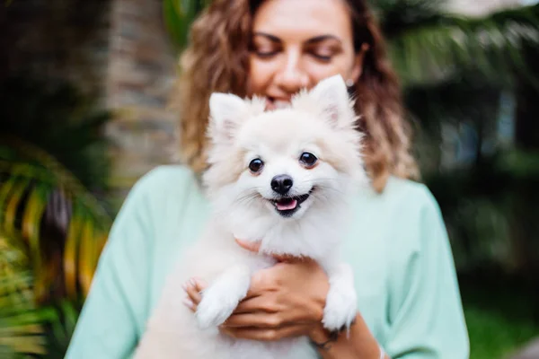 Открытый Портрет Кудрявой Европейской Загорелой Женщины Держит Счастливую Собаку Померанскую — стоковое фото