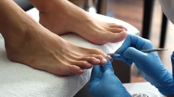 Pediküre. Salon Pediküre zu Hause. Fußpflege und Nagelpflege. Der Prozess der professionellen Pediküre. Meister in blauen Handschuhen machen Pediküre mit Maniküre-Maschine.        