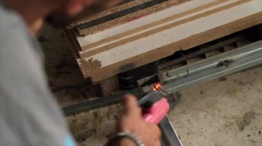 Fabrikada koruyucu maskeli bir işçi. Kaynak çelik profili. Bağlama yayı. Ateş, çalışmadan dolayı parıltı üretir