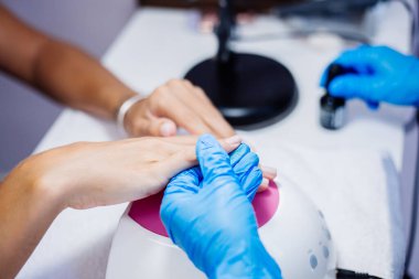 Donanım manikür süreci. Güzel kadın elleri. Tırnak tedavisi, işlem. Elektrikli profesyonel tırnak törpüsü talimi. Güzellik ve el bakımı kavramı.