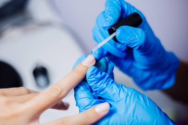 Donanım manikür süreci. Güzel kadın elleri. Tırnak tedavisi, işlem. Jöle cilası pembe, mor. Güzellik ve el bakımı kavramı.