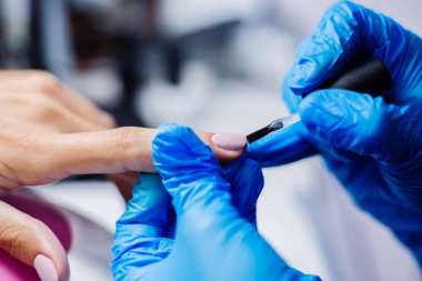 Donanım manikür süreci. Güzel kadın elleri. Tırnak tedavisi, işlem. Jöle cilası pembe, mor. Güzellik ve el bakımı kavramı.