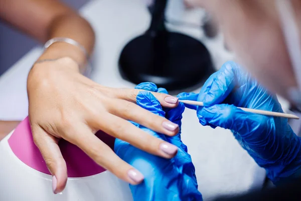 Hardware manicure process. Beautiful female hands. Finger nail treatment, making process. Gel polish pink, purple. Beauty and hand care concept.