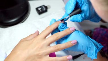 Donanım manikür süreci. Güzel kadın elleri. Tırnak tedavisi, işlem. Şeffaf taban jeli cilası uygulanıyor  