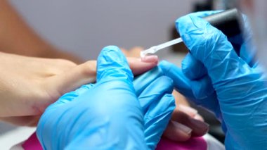 Donanım manikür süreci. Güzel kadın elleri. Tırnak tedavisi, işlem. Şeffaf taban jeli cilası uygulanıyor  