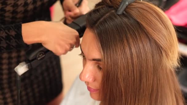 Girl Hairdresser Makes Client Keratin Hair Straightening Using Straightener Iron — Stock Video