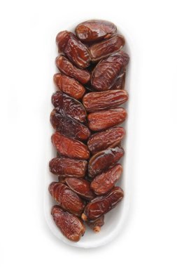 Kurumuş hurmalar beyaz arka planda izole edilmiş plastik kasede. Beyaz üzerine meyveler