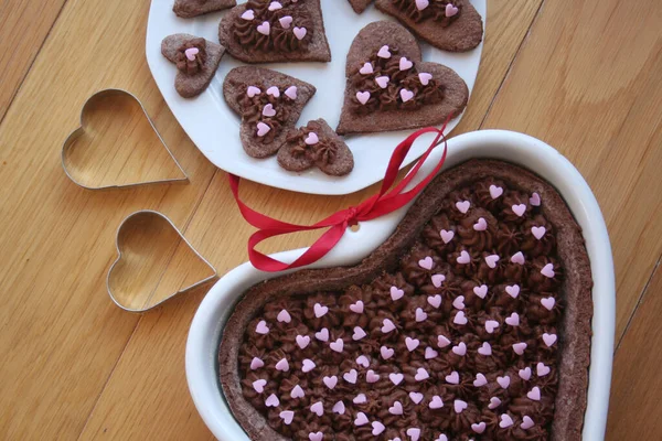 Тёмный Шоколадный Пирог Форме Сердца Тарелкой Декорированного Печенья Деревянном Столе — стоковое фото