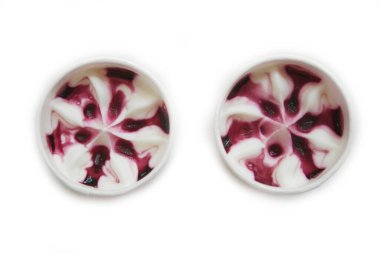 Beyaz arka planda izole edilmiş bir bardakta krema ve vişneli dondurma.