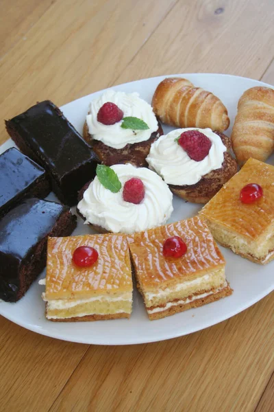 Diferentes Pasteles Con Chocolate Crema Plato Blanco Sobre Mesa Madera — Foto de Stock