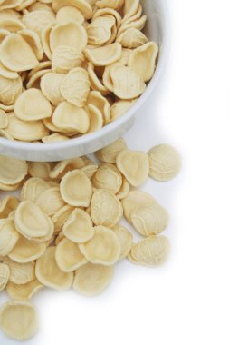 Kâsede taze bir orkestra. Beyaz arkaplanda izole edilmiş İtalyan geleneksel makarnası