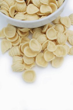 Kâsede taze bir orkestra. Beyaz arkaplanda izole edilmiş İtalyan geleneksel makarnası