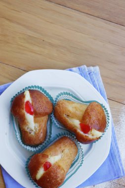 Geleneksel İtalyan tatlısının adı Bab with Rum. Tahta masadaki kremayla dolu. Napoli çöreği. 