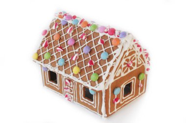 Zencefilli kurabiye evi beyaz arka planda izole edilmiş balmumu şekeri ve renkli şekerler. Noel tatlı yemeği