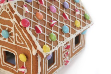 Zencefilli kurabiye evi beyaz arka planda izole edilmiş balmumu şekeri ve renkli şekerler. Noel tatlı yemeği