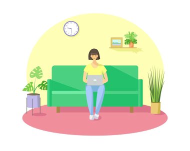 Bir kız evdeki kanepede oturuyor ve internette çalışıyor.