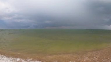 Deniz kenarında hava harika. Güneş ışınları bulutları delip geçiyor.