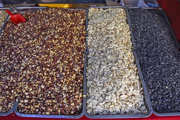 Peanuts and seeds on the counter for sale.