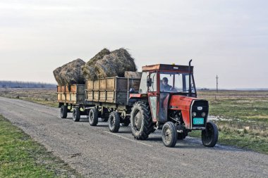 Zrenjanin, Sırbistan, 16 Kasım 2016. Traktör saman taşıyan iki römork ile.