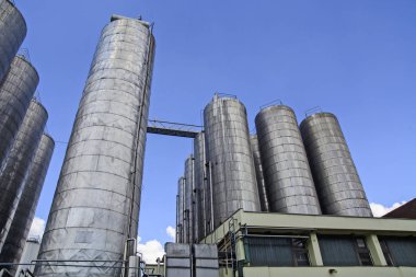 Büyük ve güçlü metal rezervuarlar fabrikada açık alanda.