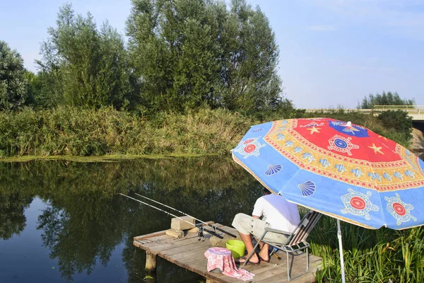 Ein Sportfischer Wartet Auf Einer Plattform Unter Dem Sonnenschirm Auf — Stockfoto