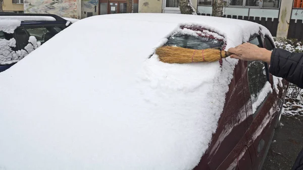 Водитель чистит снег с заднего лобового стекла — стоковое фото