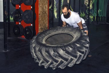 Genç sporcu büyük bir lastik dönüyor